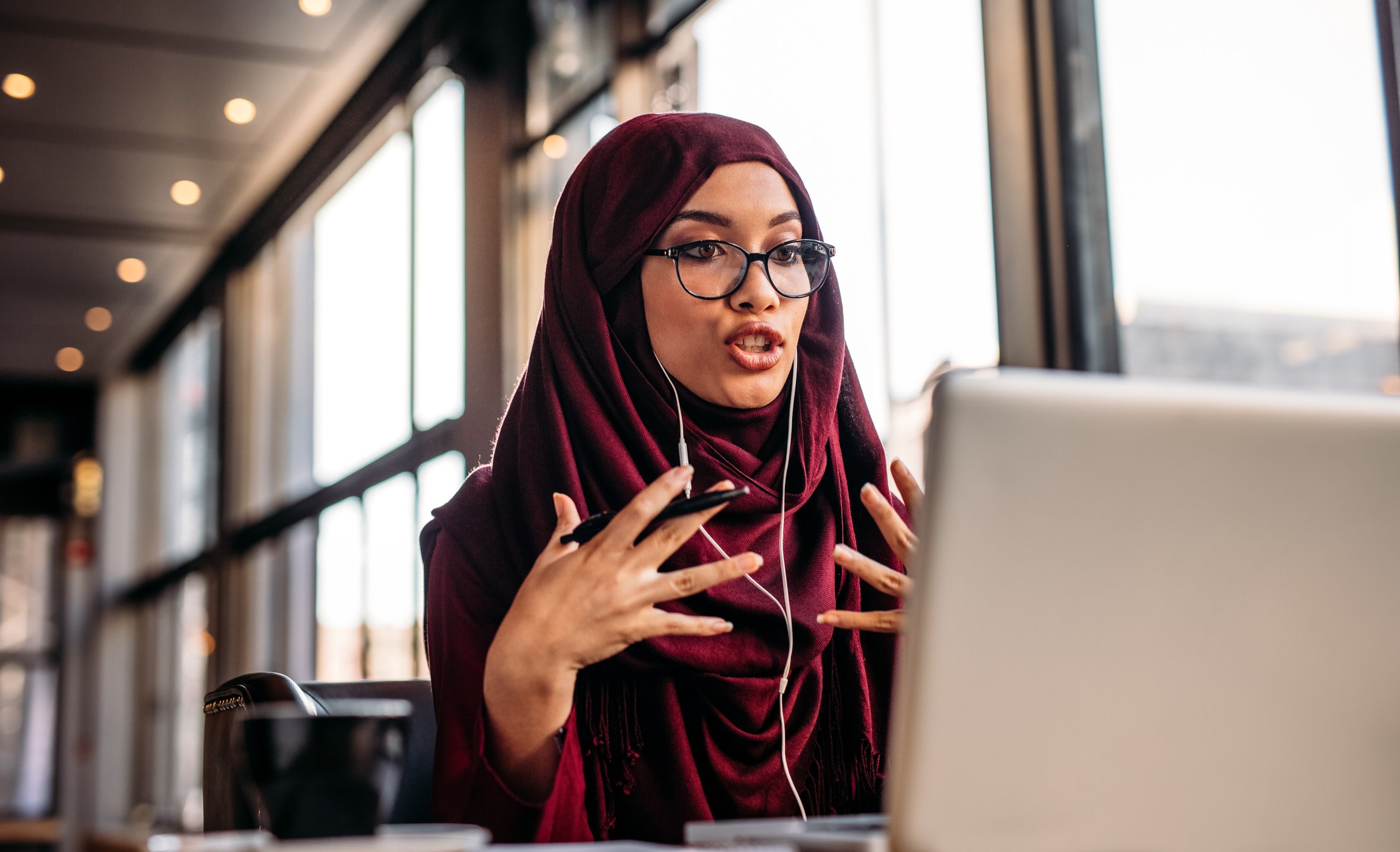 A woman in sitting in front of her computer on a virtual conference