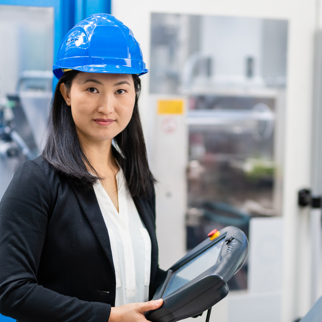 Woman in hardhat holding computer